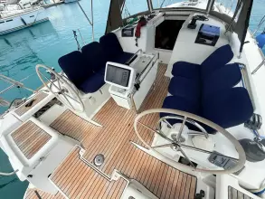 Cockpit of 2011 Jeanneau Sun Odyssey 409 sailboat with dual steering wheels and blue seating.