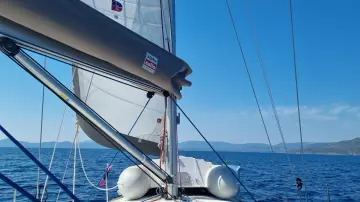 Jeanneau Sun Odyssey 409 sailing on open sea, clear blue sky, 2011 model.