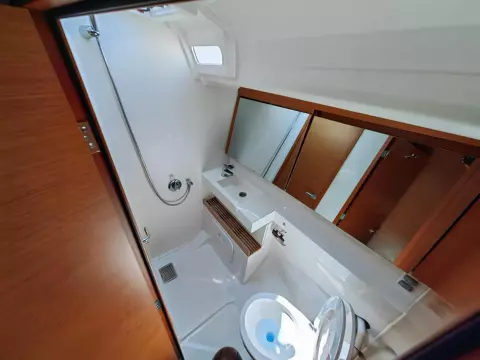 Bathroom interior of 2019 Jeanneau Sun Odyssey 440 yacht, featuring modern fixtures and wooden accents.