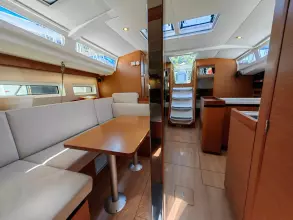 Interior of 2019 Jeanneau Sun Odyssey 440 yacht, featuring modern seating and dining area.