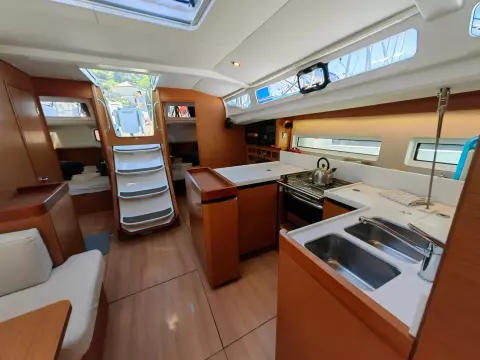 Interior of 2019 Jeanneau Sun Odyssey 440 sailboat, featuring modern kitchen and seating area.