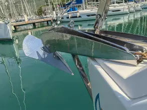 Jeanneau Sun Odyssey 440 (2019) anchor detail at marina, reflecting in calm water.