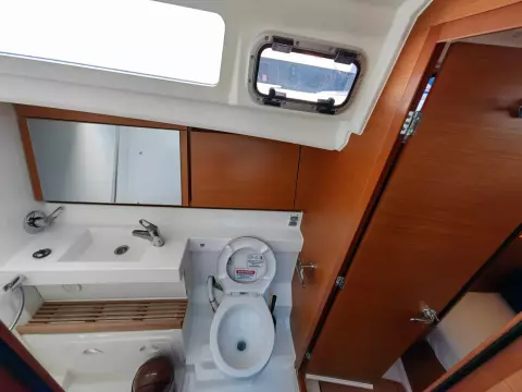 Bathroom interior of 2019 Jeanneau Sun Odyssey 440 yacht, featuring modern fixtures and wood accents.
