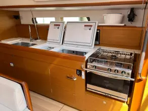 Interior of 2019 Jeanneau Sun Odyssey 479 yacht kitchen with stove and sink.