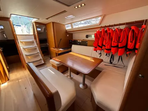 Interior of 2019 Jeanneau Sun Odyssey 479 yacht with dining area and life jackets.