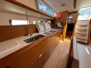 Interior of 2019 Jeanneau Sun Odyssey 479 yacht, featuring modern kitchen and wooden cabinetry.