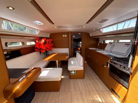 Interior of 2019 Jeanneau Sun Odyssey 479 yacht with dining area and kitchen.