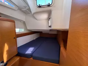 2019 Jeanneau Sun Odyssey 479 cabin with blue cushions and wooden interior.