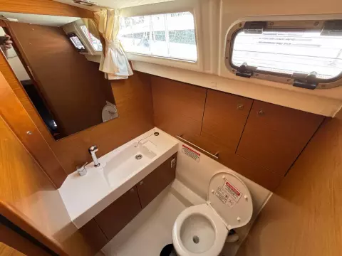 2019 Jeanneau Sun Odyssey 479 yacht bathroom with sink, toilet, and window.