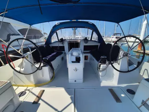 2020 Jeanneau Sun Odyssey 440 sailboat cockpit with dual steering wheels and blue canopy.