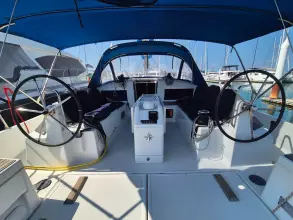 2020 Jeanneau Sun Odyssey 440 sailboat cockpit with dual steering wheels and blue canopy.
