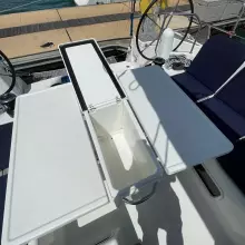 Cockpit table on 2020 Jeanneau Sun Odyssey 440 sailboat, featuring storage compartment and seating.