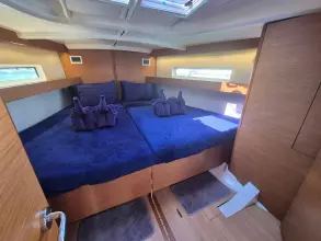 Luxurious cabin interior of 2020 Jeanneau Sun Odyssey 440 yacht with cozy bedding.