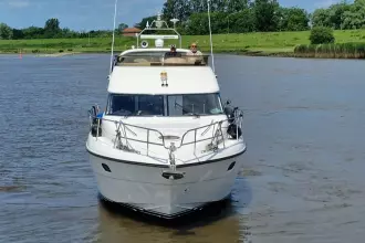 2004 Princess 45 Flybridge yacht cruising on a calm river.