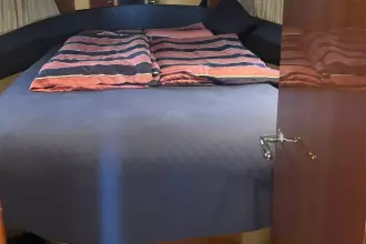 Luxurious cabin interior of 2004 Princess 45 Flybridge Motor Yacht with striped bedding.