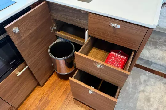 Modern kitchen cabinetry in 2024 Princess F50 yacht with fire blanket and trash bin.