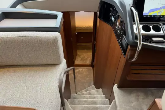 Interior of 2024 Princess F50 yacht, featuring stairs, helm, and cabin entrance.