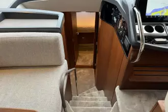 Interior of 2024 Princess F50 yacht, featuring stairs, helm, and cabin entrance.