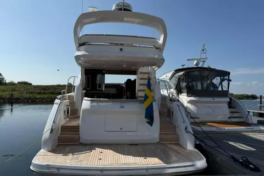 2024 Princess F50 yacht docked, rear view with Swedish flag, sunny day.