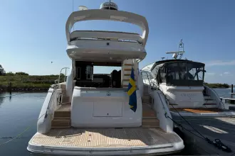 2024 Princess F50 yacht docked, rear view with Swedish flag, sunny day.