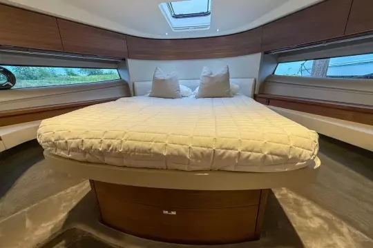 Luxurious interior of 2024 Princess F50 yacht with elegant bedding and wood accents.