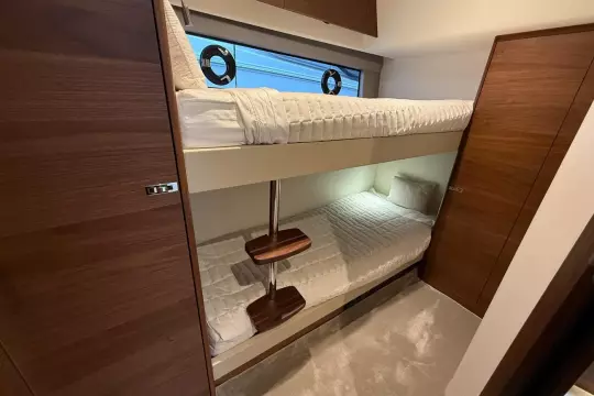 2024 Princess F50 yacht interior with cozy bunk beds and wooden accents.