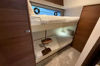 2024 Princess F50 yacht interior with cozy bunk beds and wooden accents.