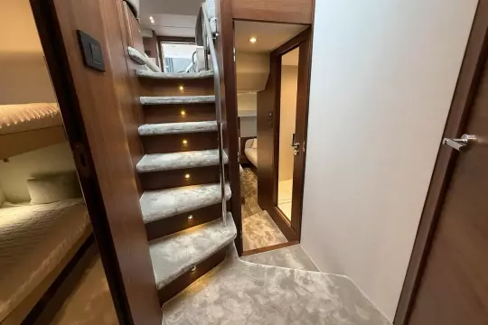 Luxurious interior of 2024 Princess F50 yacht with carpeted stairs and cozy cabin.