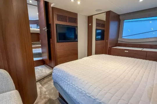 Luxurious 2024 Princess F50 yacht bedroom with modern wood finishes and large window.
