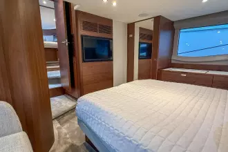 Luxurious 2024 Princess F50 yacht bedroom with modern wood finishes and large window.