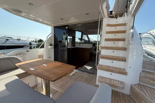 Luxurious 2024 Princess F50 yacht interior with wooden table and staircase.