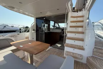 Luxurious 2024 Princess F50 yacht interior with wooden table and staircase.