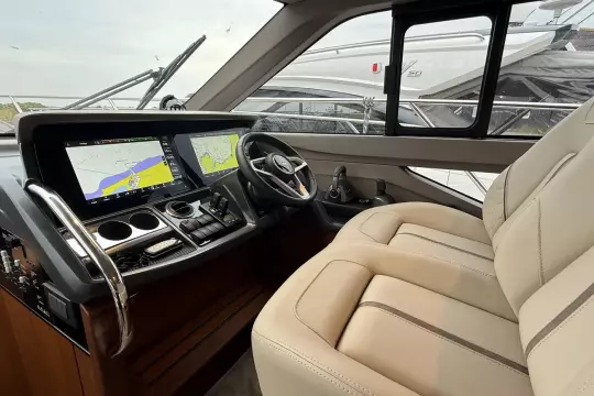 Luxurious 2024 Princess F50 yacht cockpit with advanced navigation displays and plush seating.