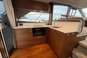 Luxurious 2024 Princess F50 yacht interior with modern kitchen and sleek wood finish.