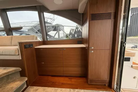 Luxurious interior of 2024 Princess F50 yacht with elegant wood cabinetry and plush seating.