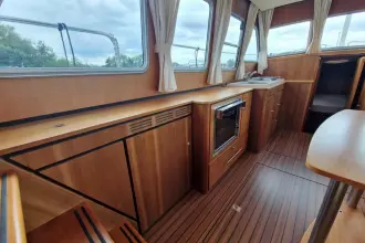 Interior of 2008 Linssen 33.9 AC yacht with wood finish and compact kitchen area.