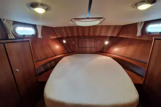 Cozy cabin interior of 2008 Linssen 33.9 AC with wood paneling and bed.