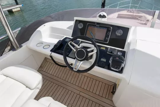Helm of 2015 Princess 60 yacht with navigation controls and steering wheel.