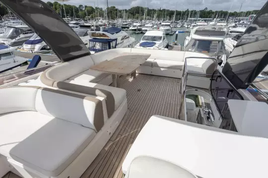 Luxurious 2015 Princess 60 yacht deck with elegant seating and marina view.