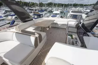 Luxurious 2015 Princess 60 yacht deck with elegant seating and marina view.