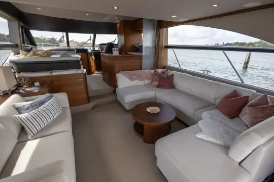 Luxurious interior of a 2015 Princess 60 yacht with elegant seating and panoramic windows.
