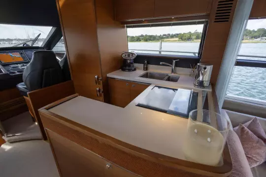 Luxurious interior of 2015 Princess 60 yacht with modern kitchen and scenic water view.