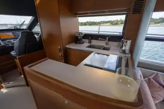 Luxurious interior of 2015 Princess 60 yacht with modern kitchen and scenic water view.