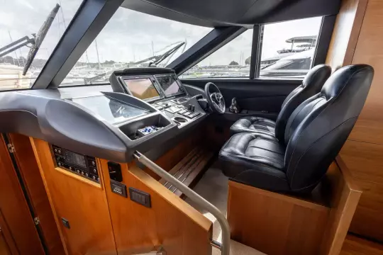 Luxurious helm of 2015 Princess 60 yacht with leather seats and advanced navigation controls.