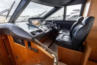 Luxurious helm of 2015 Princess 60 yacht with leather seats and advanced navigation controls.
