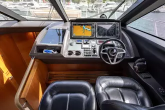Helm of 2015 Princess 60 yacht with navigation screens and leather seating.