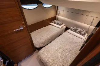 Luxurious twin cabin interior on 2015 Princess 60 yacht, featuring elegant bedding and modern design.