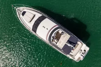 Aerial view of 2015 Princess 60 yacht cruising on green water.
