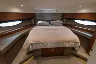 Luxurious cabin interior of 2015 Princess 60 yacht with elegant bedding and wood accents.