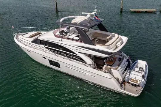 Luxurious 2015 Princess 60 yacht on serene water, featuring elegant design and spacious deck.
